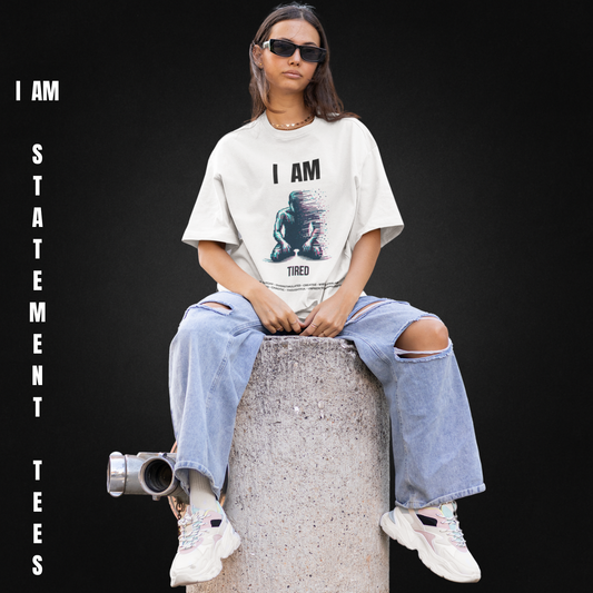 Model wearing I AM TIRED t-shirt by Mentally Glitched, seated with a neutral black background