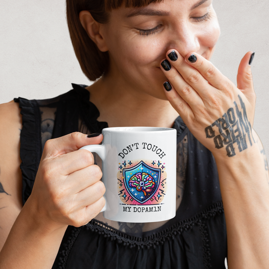 Woman laughing while holding a white mug that says “Don’t Touch My Dopam1n” with a colorful brain and shield illustration – Mentally Glitched neurodivergent mug.